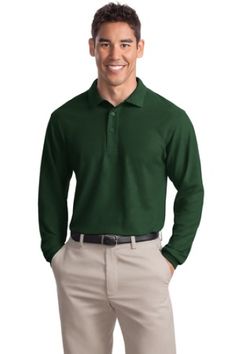 a man in green shirt and khaki pants standing with his hands on his hips