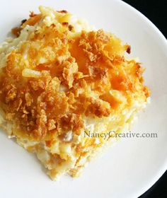 a white plate topped with mashed potatoes covered in gravy and crumbs