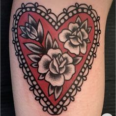 a heart tattoo with roses and leaves on it