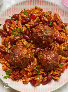 a white plate topped with meatballs and pasta covered in red sauce next to a fork