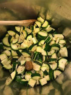 chopped zucchini and other vegetables in a bowl with a wooden spoon