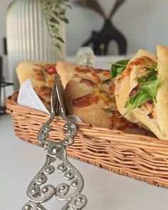 a basket filled with slices of pizza on top of a table next to a pair of scissors