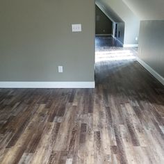 an empty room with hard wood flooring and gray paint on the walls is seen in this image