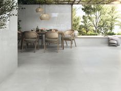 a dining room with white tile flooring and wooden chairs