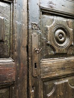 an old wooden door with a metal handle