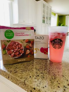 starbucks iced drink and frozen strawberries are sitting on the kitchen counter next to each other