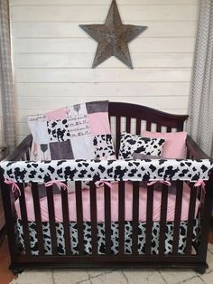 a baby crib with pink, black and white bedding