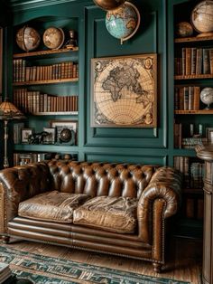 a living room with green walls and leather couches in front of bookshelves