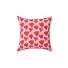 a pink pillow with red strawberries on the front and green leaves on the back