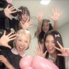 four young women are posing for a photo with balloons in front of their faces and hands