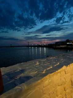 a person standing on the edge of a pier at night