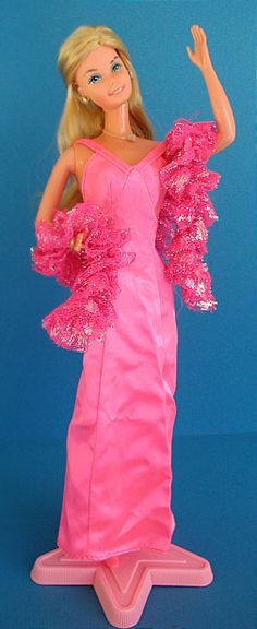 a barbie doll wearing a pink dress and holding a frisbee in her hand