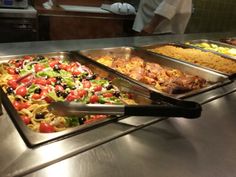 several trays of food sitting on top of a counter