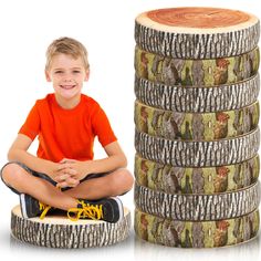 a young boy sitting on top of a pile of coins next to a tree stump