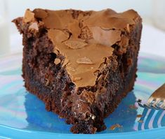 a piece of chocolate cake sitting on top of a blue plate