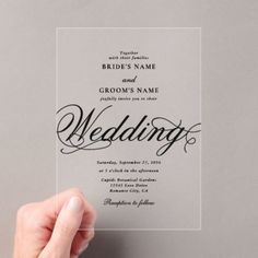 a person holding up a wedding card with the word's name in black ink