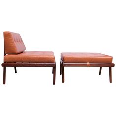 two brown leather lounge chairs and ottomans with wooden legs, one is facing the other