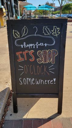 a chalkboard sign that says it's shop o'clock somewhere on the sidewalk