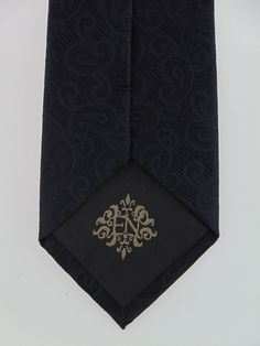 "Mens black on black 100% silk necktie. Available as a extra long tie. Handmade from 100% silk, this special collection features a .75\" Eds Neckties logo at the bottom right front corner of every tie and a larger logo located on the tipping (Back of the tie). The label features the collection name (Nathaniel Alexandria) Named after my son Nathaniel and my daughter Alexandria. Expertly hand-made from 100% silk you can select your length from 57\" to 63\" (Great for taller Men). Width is standard Black Formal Ties For Father's Day, Black Fitted Suit And Tie Accessories For Father's Day, Elegant Ties For Black Tie Events And Father's Day, Elegant Black Tie For Father's Day, Silk Mark Certified Ties For Black Tie Events, Silk Mark Certified Standard Tie For Black Tie Events, Standard Silk Mark Certified Ties For Black Tie Events, Classic Silk Mark Certified Ties, Designer Formal Suit And Tie Accessories