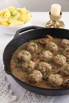 a pan filled with meatballs and mushrooms on top of a table