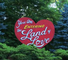 a large red heart shaped sign with the words you are entering the land of love