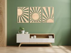 a living room with green walls and wooden artwork on the wall, along with a white entertainment center