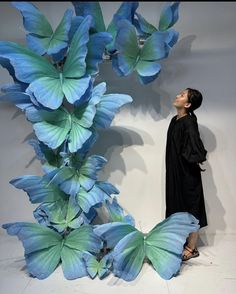 a woman standing in front of blue butterflies