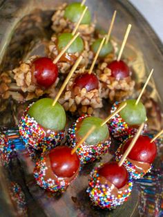 fruit and nuts on skewers with sprinkles are served on a platter