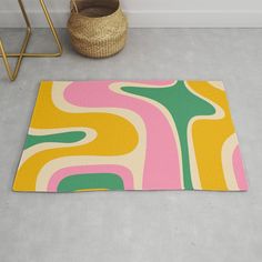 a rug with an abstract design on the floor next to a basket and planter