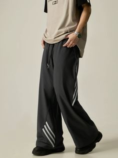 Effortlessly combine comfort and style with these Wide-Leg Drawstring Track Pants. Featuring a stylish contrast stripe design and a convenient drawstring waist, these pants offer a relaxed fit and modern look. Perfect for workouts or casual days, these pants are a must-have addition to your wardrobe. model: 174cm 61kg M material: 90% polyamide fiber (nylon). 10% polyurethane elastic fiber (spandex) Gray Wide Leg Sweatpants With Drawstring, Gray Wide-leg Sweatpants With Drawstring, Black Casual Sweatpants With Contrast Stripes, Casual Sweatpants With Contrast Stripes And Relaxed Fit, Casual Striped Streetwear Pants, Casual Wide Leg Sweatpants With Three Stripes, Casual Black Bottoms With Contrast Stripes, Black Pants With Contrast Stripes For Loungewear, Casual Wide Leg Pants With Contrast Stripes