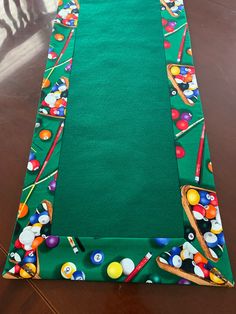 a green table runner with pool balls and cues on it, ready to be decorated