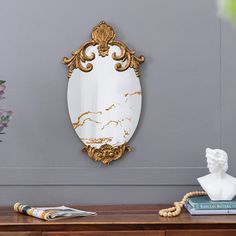 a mirror sitting on top of a wooden table next to a vase with flowers in it