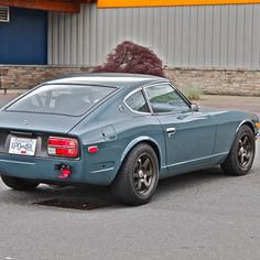 a blue sports car parked in front of a building