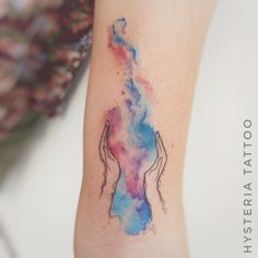 a woman's arm with a watercolor tattoo on the left side of her body