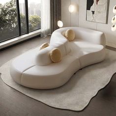 a white couch sitting on top of a rug in a living room next to a window