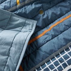 the inside of a quilted jacket with an orange and blue stripe down the middle