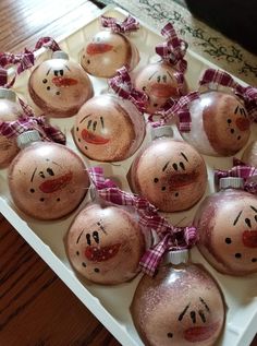 christmas ornaments with faces are arranged in a tray on the table, ready to be decorated