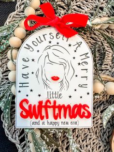 a christmas ornament with a red bow on the front and white lettering that says, have you're a little suftmas and a happy new era