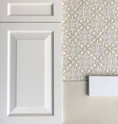 a white cabinet door next to a wall with a paper towel dispenser on it