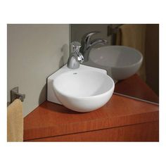 a white bowl sink sitting on top of a wooden counter