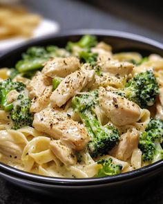 a bowl filled with chicken and broccoli on top of a table