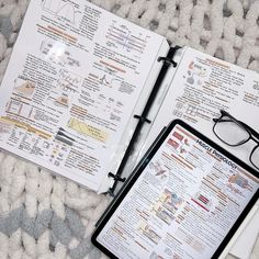 an open book with glasses on top of it next to a pair of eyeglasses