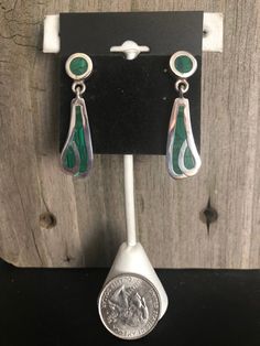 Malachite and Sterling Silver Earrings Southwestern Beautiful green Malachite is inlayed into Sterling Silver to create these gorgeous Southwestern-style earrings. The earrings come in two pieces connected together to create an attractive dangle drop style. These gorgeous earrings are finished off with post backs. They are stamped on the backs with the artisan's number, 925 (Sterling) and Mexico, denoting their country of excellent craftmanship. Length: 1-1/2 inches Width: 1/2 inch Weight: 12 gr Green Southwestern Style Jewelry With Inlay, Southwestern Style Green Inlay Jewelry, Nickel-free Green Southwestern Jewelry, Handmade Southwestern Green Earrings, Southwestern Green Teardrop Earrings, Green Teardrop Southwestern Jewelry, Sterling Silver Jewelry With Green Inlay, Green Artisan Pierced Earrings, Southwestern Green Sterling Silver Earrings