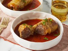 two white bowls filled with meatballs covered in sauce