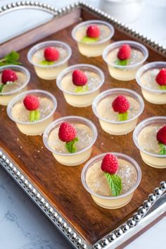 small desserts with raspberries are arranged on a tray