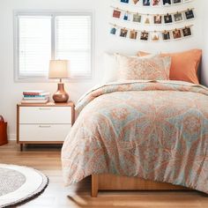 a bed room with a neatly made bed and pictures hanging on the wall above it