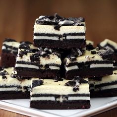 a white plate topped with brownies covered in oreo cookies and cream frosting