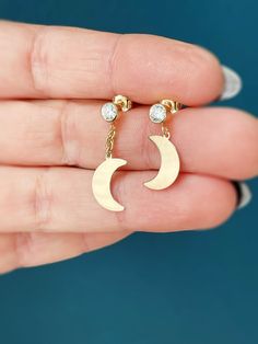 Crafted in radiant 14K gold, these dangle earrings elegantly pair a cubic zirconia studs with a crescent moon charms. Crescent moon is flat with clean, rounded lines and elegant shape. The reflective finish of the moon charm, as well as a diamond sparkle of cubic zirconia stud, catch the light beautifully making these earrings absolutely magical. Available in various styles - SHORT - stud with the moon charm, - LONG - with a few chain links to allow for more movement - MISMATCHED - One short and Minimalist Yellow Gold Earrings With Moon Charm, Celestial Yellow Gold Cubic Zirconia Earrings, Dainty Yellow Gold Earrings With Moon Charm, 14k Gold Crescent Earrings For Anniversary, 14k Gold Crescent Pierced Jewelry, Elegant Gold Plated Moon-shaped Earrings, 14k Gold Crescent Shaped Pierced Jewelry, Elegant Moon Shaped Gold Plated Earrings, Elegant Moon-shaped Gold Plated Earrings