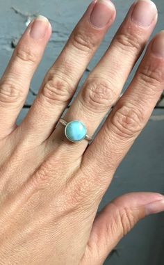 A stunning ethereal sky ocean blue round larimar has been set in sterling silver with a handmade ring band from sterling silver half dome wire. The stone is 11mm round and has interchanging hues of light and white running throughout. Choose your stone from the last photo in the listing. This will be the exact stone used in your ring!Larimar is the embodiment of the tranquil Sea and Sky energies. Its soft, soothing blues and calming turquoise is streaked with white patterns that resemble sunlight Blue Larimar Round Rings, Adjustable Round Aquamarine Jewelry, Adjustable Aquamarine Round Jewelry, Adjustable Aquamarine Jewelry, Adjustable Aquamarine Bracelet, Silver Amazonite Round Jewelry, Adjustable Larimar Jewelry For Anniversary, Turquoise Moonstone Ring In Sterling Silver, Turquoise Larimar Cabochon Jewelry