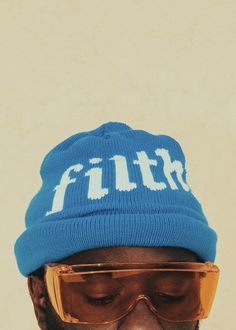 a man wearing sunglasses and a blue hat with the word faith on it's side